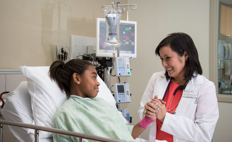 Teenage patient and doctor holding hands
